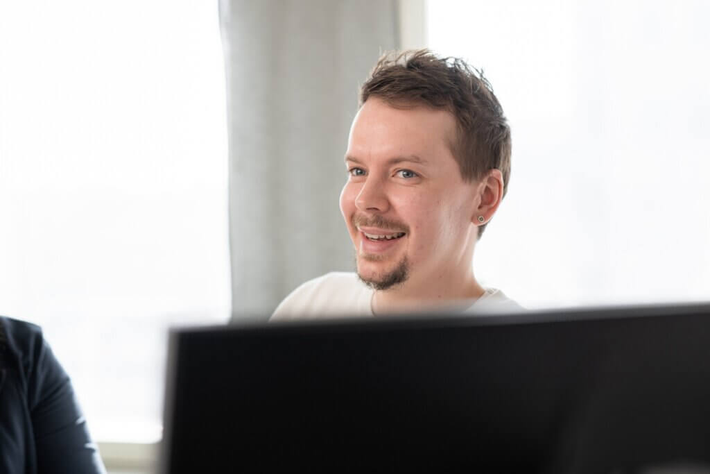 WorkPowerin toimihenkilö istuu hymyillen.