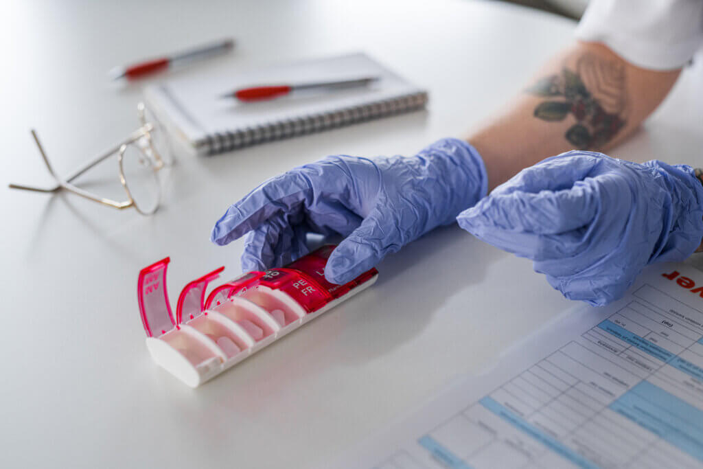 Hoitoalan työntekijä jakamassa lääkkeitä dosettiin.