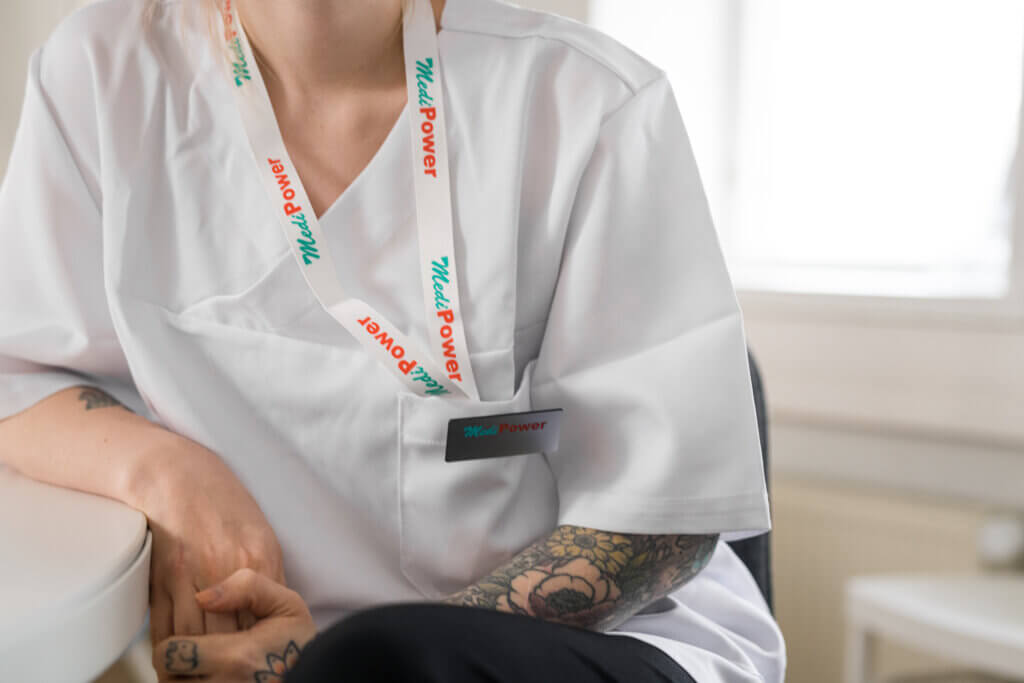 MediPowerin työntekijä kaulassa MediPowerin logolla varustettu avainnauha.