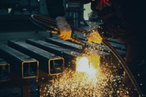 Kuvassa hitsaaja työssään, jossa kipinät lentää ja tulityövahdille tarve.