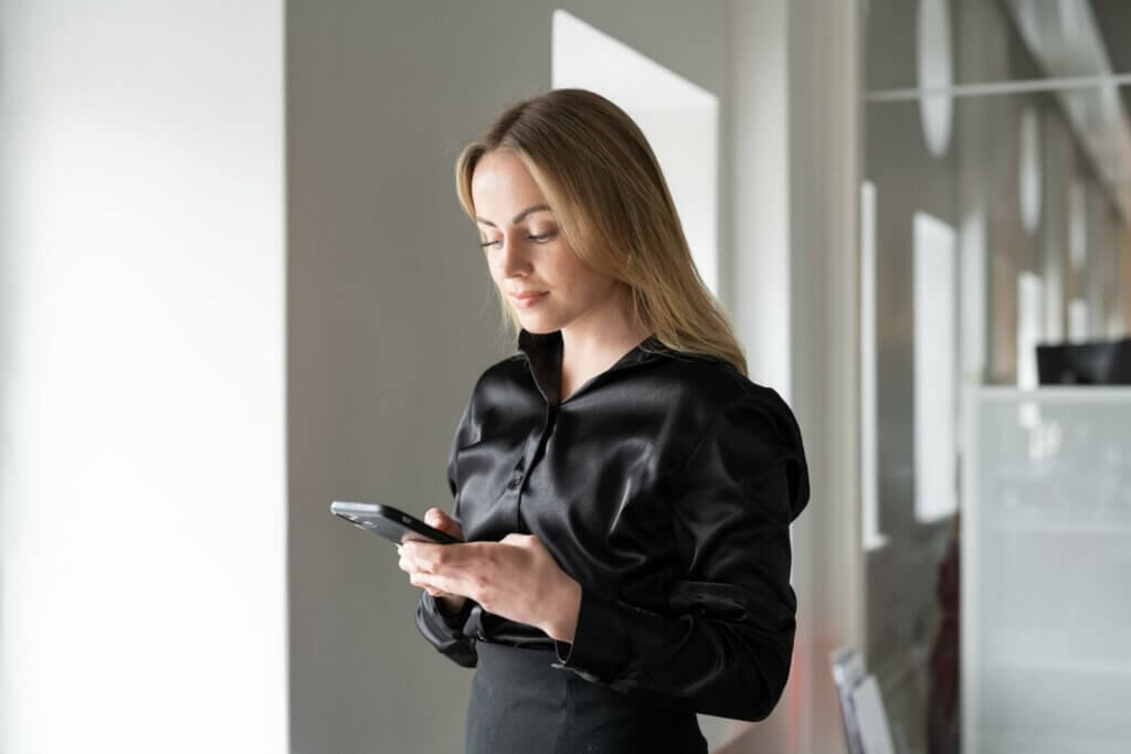 Kuvassa naishenkilö selaa puhelimellaan WorkPowerin somea.