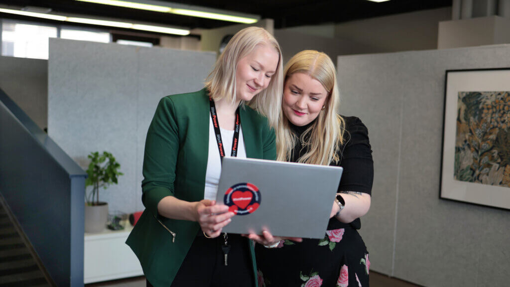 WorkPowerin kaksi toimihenkilöä silmäilevät tietokonetta.